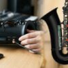 YDS-120デジタルサックスと、安全な外付けBluetoothレシーバーの接続例（左）と、リスクのある内部キーメカニズムへの分解（右）を対比させた、アイキャッチ用の合成画像。